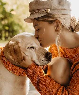 A woman hugging her happy dog.